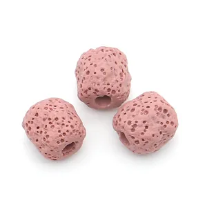 Close-up of pink volcanic stone cylindrical beads with porous texture for jewelry making