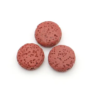 Macro shot of three reddish-brown flat lava stone beads showing porous texture for DIY jewelry