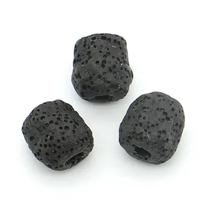 Macro detail of three black lava stone cylinder beads showing natural porous texture