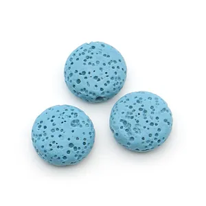 Macro view of three light blue lava stone flat beads with porous texture for DIY jewelry