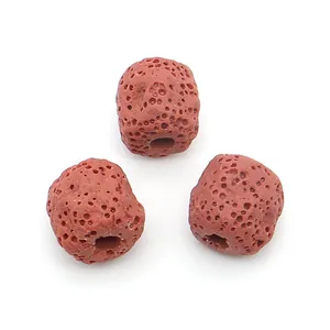Macro shot of three porous reddish-brown lava stone beads with center holes for DIY jewelry