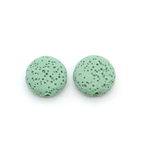 Close-up of two light green porous lava stone beads for DIY jewelry making