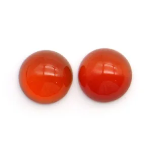 Primo piano di due cabochon tondi in corniola arancio-rossa per la creazione di gioielli