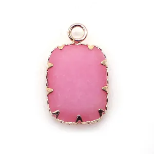 Macro detail van rechthoekige rozenkwarts hanger met goud vergulde klauwzetting