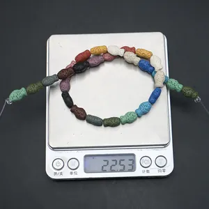 Dettaglio di perle in pietra lavica colorata a forma di pesce su una bilancia per gioielli
