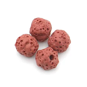 Macro shot of four porous reddish-brown volcanic lava stone beads for jewelry DIY