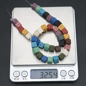 Macro shot of 10mm colorful porous volcanic lava stone cube beads on electronic scale