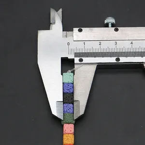 Macro shot of colorful cubic lava stones being measured with a metal caliper tool
