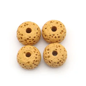 Macro view of four porous earthy yellow lava stone beads with central holes for DIY jewelry