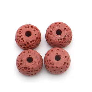 Close-up of four reddish-brown volcanic lava stone beads with porous texture for DIY jewelry