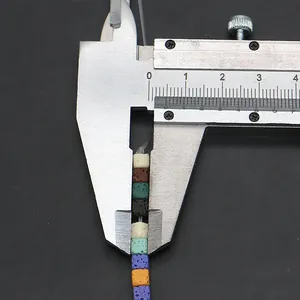 Macro shot measuring colorful square lava stone beads with a digital caliper tool