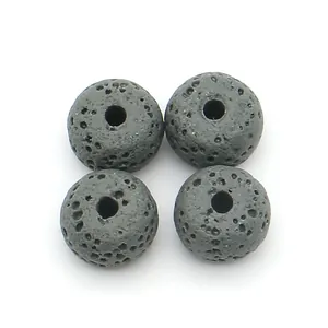 Close-up of four black lava stone rondelle beads with porous texture for DIY jewelry