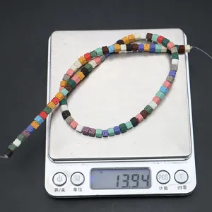 Detailed view of colorful volcanic stone cube beads on electronic scale showing weight