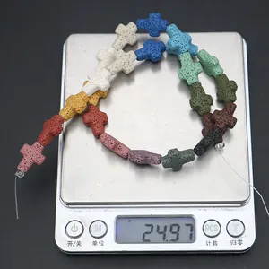 Gros plan de perles en pierre de lave colorées en forme de croix sur une balance de précision