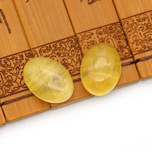 Close-up van twee ovale gele doorschijnende edelsteen cabochons op vintage bamboe basis