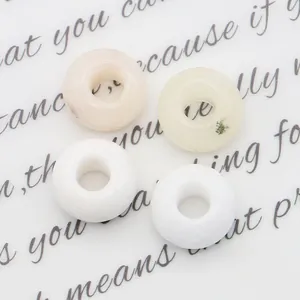 Macro-opname van vier diverse natuurstenen kralen met groot gat voor DIY-sieraden maken