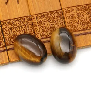 Macro-opname van twee gepolijste ovale tijgeroog cabochons met chatoyancy op bamboe