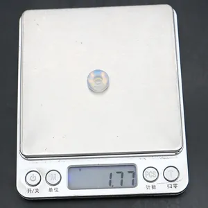 Macro-opname van een kleine opalen donut kraal op een digitale weegschaal van 1,77g voor DIY