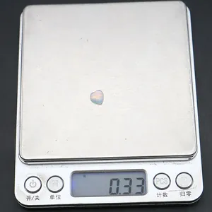 Vista macro di un opale a forma di cuore del peso di 0,33 g su una bilancia digitale