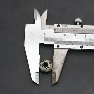 Dettaglio di una perla rotonda in diaspro dalmata da 10 mm con foro centrale per gioielli