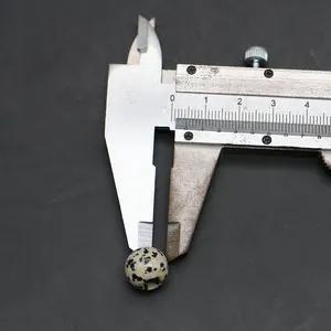Misurazione ravvicinata di una perla in diaspro dalmata da 10mm con un calibro