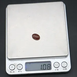 Macro-opname van een 1,08 g rode ovale agaat edelsteen op een precisie digitale weegschaal