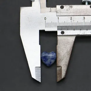 Misurazione di una perla in pietra naturale blu a forma di cuore con un calibro d'argento