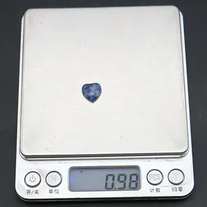 Vista dettagliata di una pietra naturale blu a forma di cuore da 0,98 g sulla bilancia