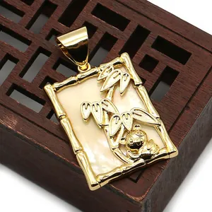 Detalle de un colgante de oro con panda y bambú sobre fondo de nácar luminiscente
