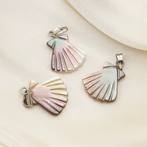 Détail de trois pendentifs en nacre naturelle avec fermoirs en argent sur soie blanche