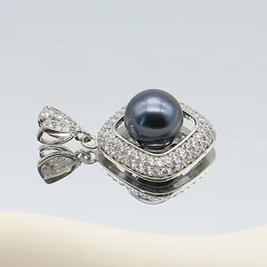 Macro shot of silver flower pendant with dark pearl and sparkling cubic zirconia pavé
