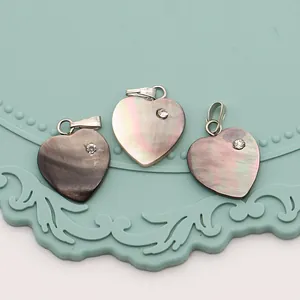 Détail de pendentifs en nacre en forme de cœur avec accents de petits strass brillants