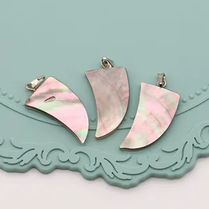 Détails macro de pendentifs en nacre naturelle en forme de croissant avec fermoirs argent