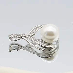 Macro view of silver flower pendant with large white pearl and pave set zirconia crystals