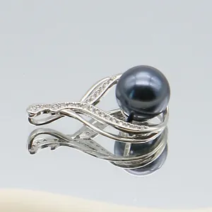 Macro shot of black pearl pendant with silver curved setting and inlaid cubic zirconia