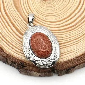 Macro detail of oval locket with sparkling goldstone and floral relief on wood background