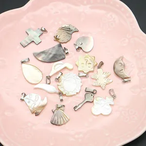 Pendentifs en nacre naturelle de formes variées avec attaches argentées sur plateau décoratif