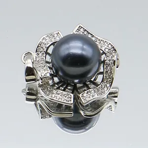 Macro shot of black pearl pendant with silver flower petals and micro-pave zircons