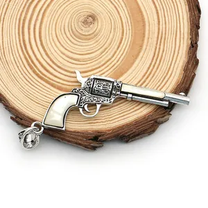 Vue détaillée du pendentif pistolet avec incrustation de nacre sur socle bois