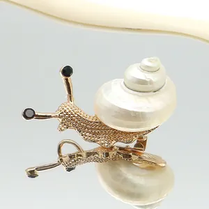 Foto macro de broche de caracol con textura de metal dorado e incrustación de concha