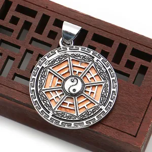 Detailed close-up of retro silver Tai Chi Yin Yang shell pendant on wooden stand