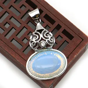 Macro shot of silver filigree peacock pendant featuring an oval light blue stone