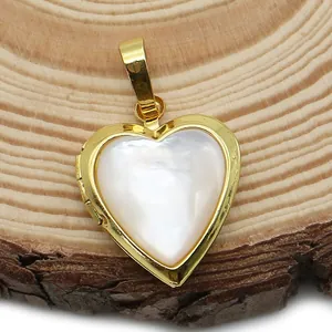 Dettaglio di un medaglione a cuore dorato con inserto in madreperla bianca su legno