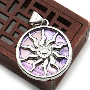 Close-up of a silver sun totem pendant with purple shell inlay on a wooden display