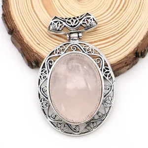 Macro shot of oval pink agate stone in vintage hollowed-out silver alloy pendant