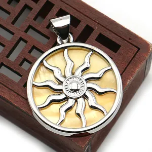 Detailed close-up of a silver sun totem pendant with yellow iridescent shell inlay