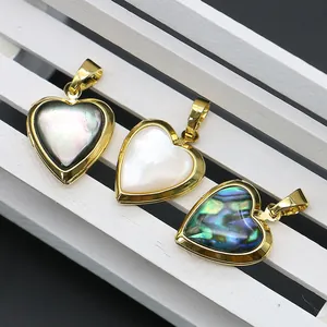 Pendenti a cuore dorati con inserti in madreperla su espositore in legno bianco