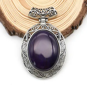 Macro detail of oval purple gemstone pendant with silver filigree on a wooden base