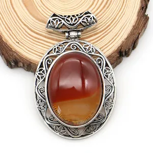 Detailed close-up of oval agate pendant with hollow filigree vintage silver design