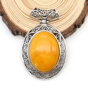 Macro detail of oval yellow agate pendant with hollow silver zinc alloy carving